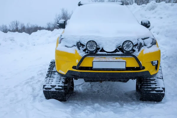 Rastejador veículo amarelo vista direta na neve de inverno — Fotografia de Stock