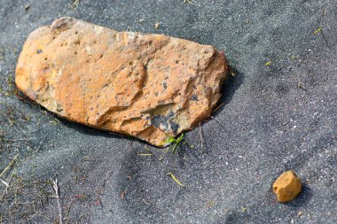 Bulanık arkaplanda kıyıya yakın çakıl taşları.