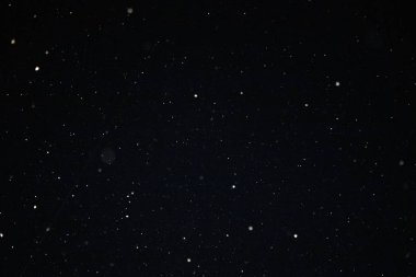 Siyah arka plandaki bir fenerin ışığında kar ve bokeh