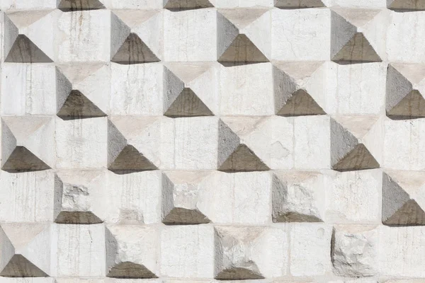 Textuur met uitstekende piramides van oude betonnen muur — Stockfoto