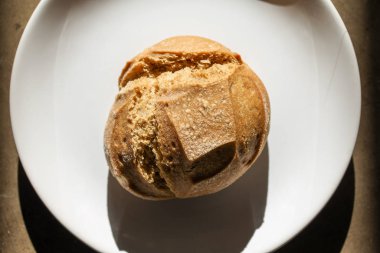 Yumuşak, taze pişmiş beyaz ekmek, beyaz bir tabakta kıtır kıtır.