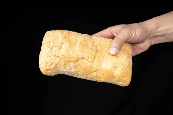 Siyah arka planda erkek elinde taze ekmek ciabatta. — Stok fotoğraf