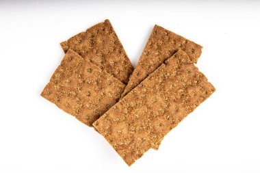 Tahıl diyeti hafif çıtır ekmek, beyaz arka planda kalp şeklinde yatıyor.