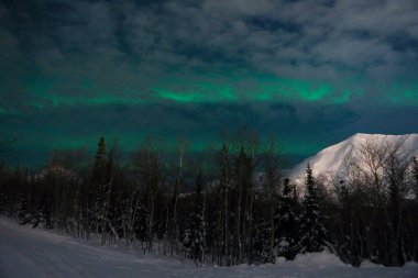 Arka plandaki gece dağlarında kuzey ışıkları