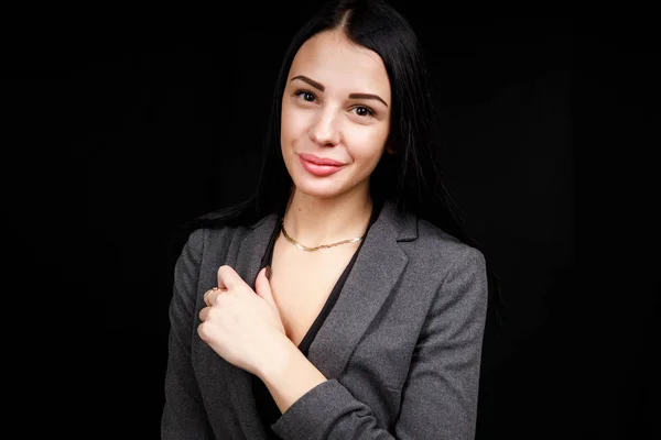 Retrato de una joven mujer de negocios con chaqueta gris sobre fondo negro — Foto de Stock