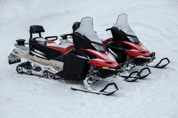 İki kırmızı kar aracı karın üzerinde duruyor. Kış motosikleti. Kar arabaları. Kışın Atvs 