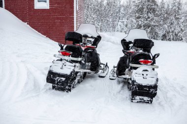 İki kırmızı kar aracı karın üzerinde duruyor. Kış motosikleti. Kar arabaları. Kışın Atvs 
