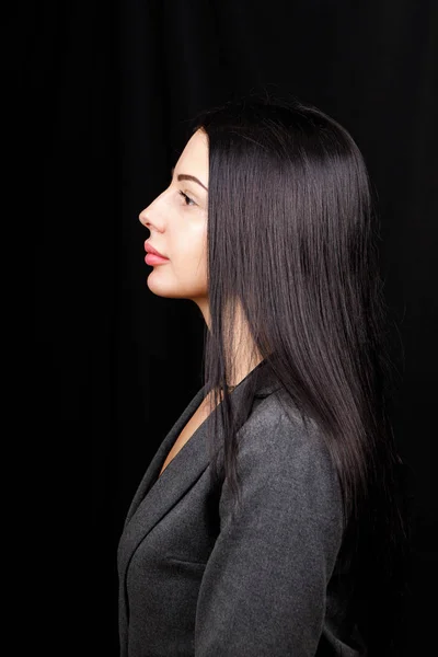 Profile portrait of a cute gorgeous girl with a beaming smile plump lips in casual dress on black background with copy space empty space — 스톡 사진