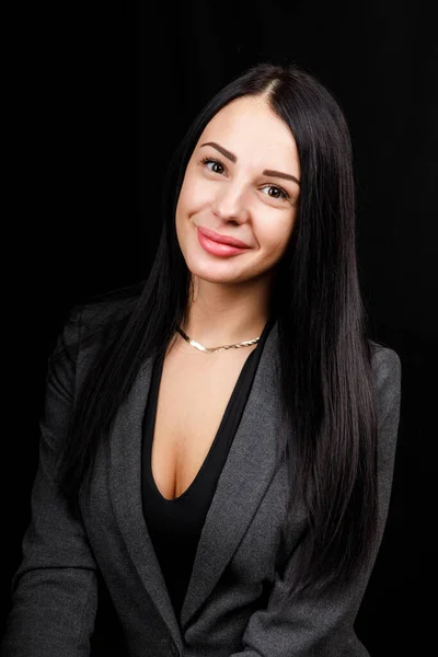 Retrato de una joven mujer de negocios con chaqueta gris sobre fondo negro — Foto de Stock