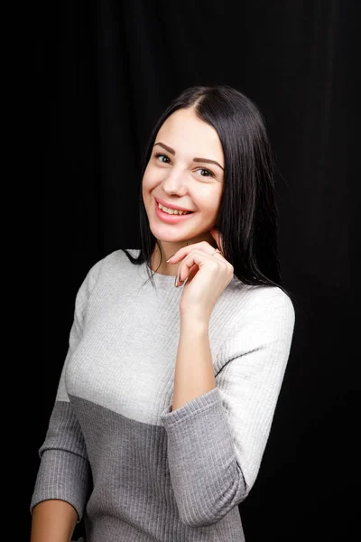 Retrato de mulher pensativa mantém a mão sob o queixo, olha para a câmera para se lembrar de algo ou ouve algo com interesse, vestido casualmente, posa dentro de casa. Conceito de juventude — Fotografia de Stock