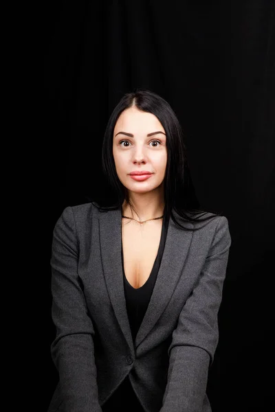 Retrato de jovem mulher de negócios em uma jaqueta cinza no fundo preto — Fotografia de Stock