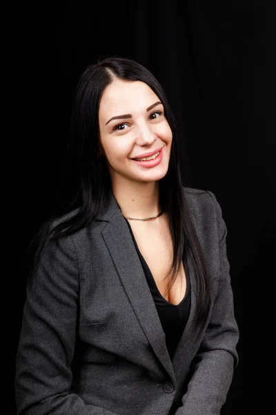 Портрет молодой деловой женщины в серой куртке на черном фоне — стоковое фото