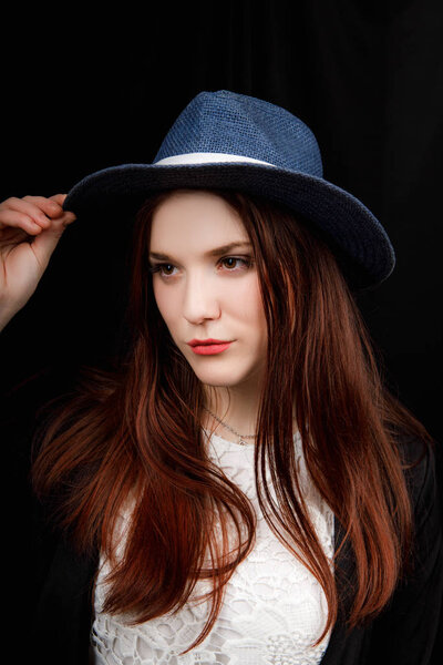 Beautiful woman portrait with a big hat. Vintage look. Fashion makeup. The hat covers part of the face