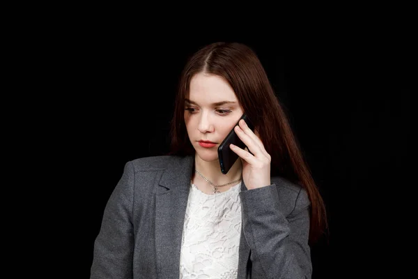 Neşeli ve başarılı genç moda blogcusu telefonda duygusal olarak konuşuyor. Gri ceketli güzel bir kadın elinde akıllı telefon tutuyor. — Stok fotoğraf