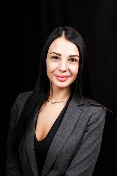 Retrato de una joven mujer de negocios con chaqueta gris sobre fondo negro — Foto de Stock
