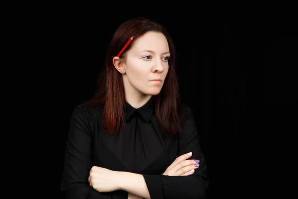 Portrait of successful business woman in  a black shirt with crossed hands on black background Stock Photo