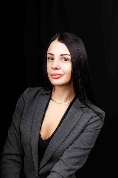 Retrato de una joven mujer de negocios con chaqueta gris sobre fondo negro — Foto de Stock