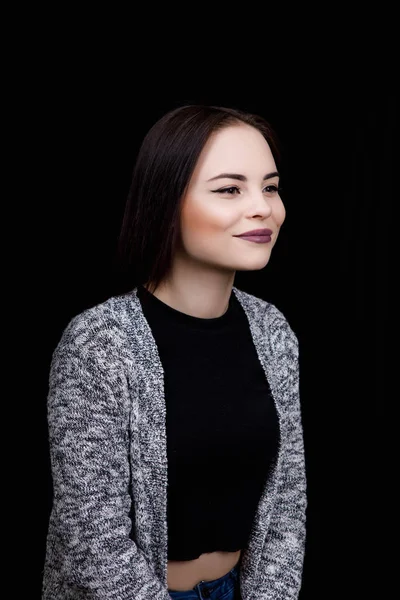 Menina bonito vestido em desgaste casual está sorrindo no fundo preto — Fotografia de Stock