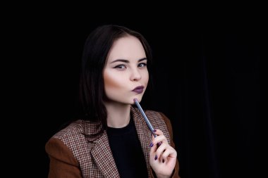 Düşünceli kız mühendis elinde kalemi döndürüyor ve bir şeyler düşünüyor..