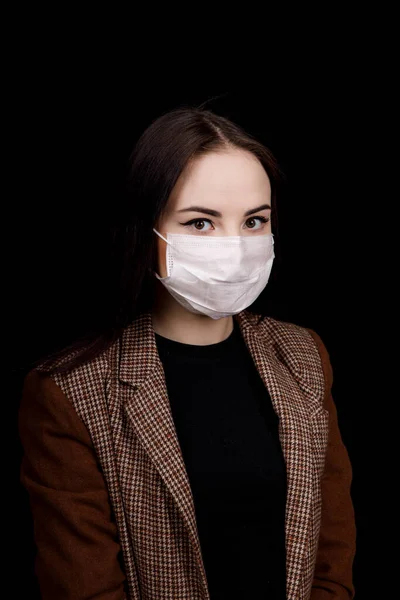 Girl in a scarf and a medical mask is afraid of contracting the virus