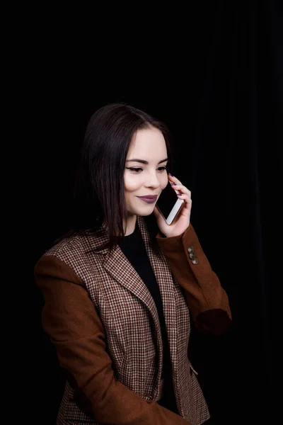 Joyful and successful young woman fashion blogger is emotionally talking on phone. Mulher bonita na jaqueta cinza casual está segurando smartphone — Fotografia de Stock