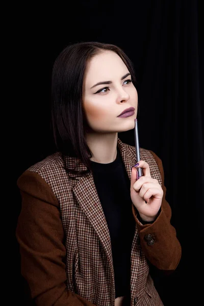Töprengő lány mérnök megcsavarja a tollat a kezében, és gondolkodik valami. — Stock Fotó