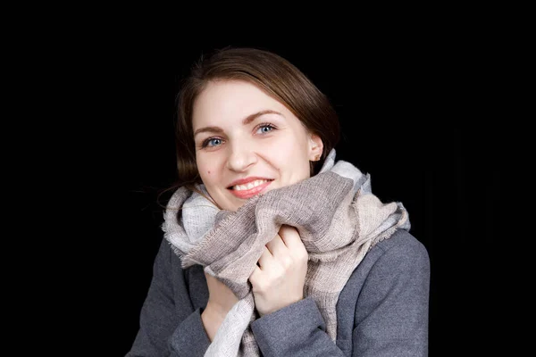 Das Mädchen ist in einen grauen Schal gehüllt. Porträt aus nächster Nähe — Stockfoto