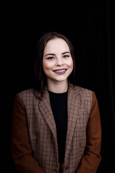 Menina bonito vestido em desgaste casual está sorrindo no fundo preto — Fotografia de Stock