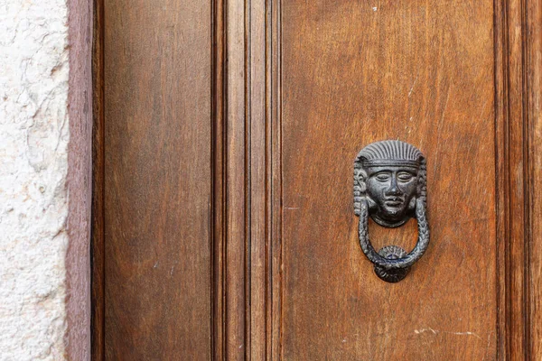 Puerta marrón madera vieja con manija de la puerta del metal. Fondo texturizado arquitectónico con una parte de pared blanca —  Fotos de Stock