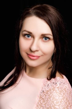 Studio close up portrait of a girl of Slavic appearance with blue eyes. on a black background
