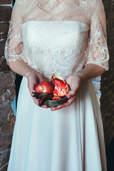 Gadis dalam gaun pengantin memegang buah delima di telapak tangan — Stok Foto