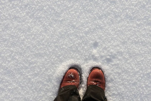 Вид зверху на червоні або коричневі шкіряні чоботи або сніжне взуття на снігу з вище копіювального простору . — стокове фото