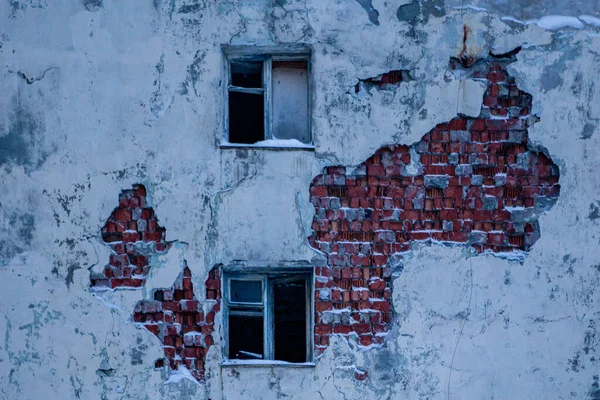 Zbite okna starego opuszczonego budynku na pękniętej betonowej ścianie z czerwonymi cegłami — Zdjęcie stockowe