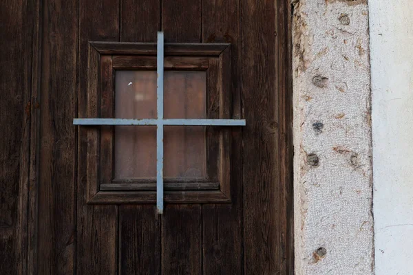 Una pequeña ventana de visualización en la vieja puerta de madera en Portugal —  Fotos de Stock