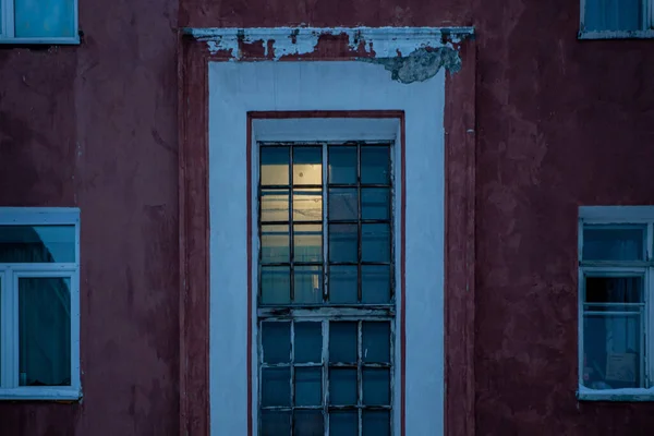 Janelas da casa e entrada de vidro na parede de concreto vermelho coberto com neve — Fotografia de Stock