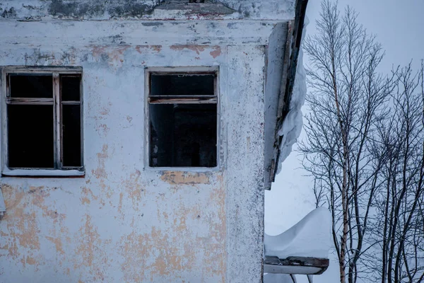 Fenêtres cassées d'un ancien bâtiment abandonné sur un mur de béton fissuré avec briques rouges — Photo