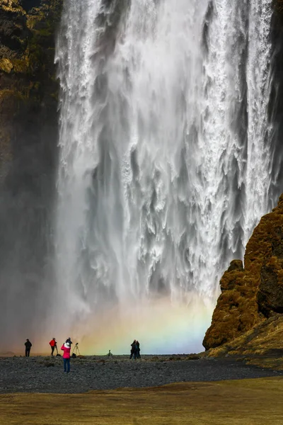 Mäktigt vattenfall på Island med regnbåge och människorna framför — Stockfoto