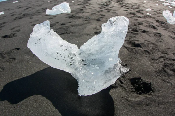 Il blocco di ghiaccio giace sulla sabbia vulcanica nera sulla "spiaggia di Diamante" in Islanda — Foto Stock