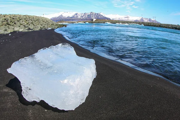 氷の塊はアイスランドの「ダイヤモンドビーチ」の黒い火山砂の上に横たわっています — ストック写真