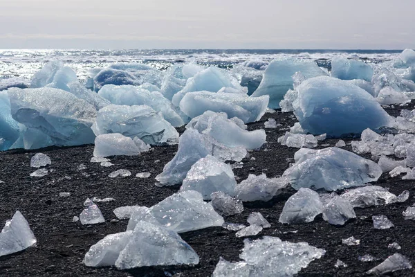 O bloco de gelo está deitado na areia vulcânica preta na "Diamond Beach", na Islândia — Fotografia de Stock