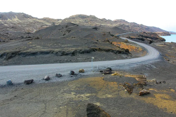 Route courbe entre les champs de lave. Route de campagne vers nulle part — Photo