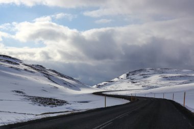 İzlanda 'da asfalt yol ve doğa manzaralı dağlar