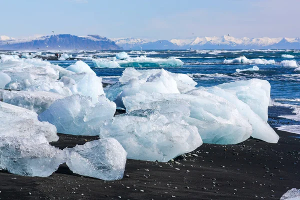 Bellissimo ghiaccio bianco e blu su sabbia vulcanica nera su "Diamond beach" in Islanda — Foto Stock