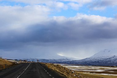 İzlanda 'da asfalt yol ve doğa manzaralı dağlar