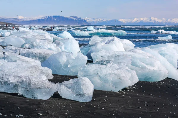 Bellissimo ghiaccio bianco e blu su sabbia vulcanica nera su "Diamond beach" in Islanda — Foto Stock