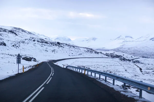 아이슬란드의 겨울 풍경입니다. 눈으로 뒤덮인 아스팔트 길 — 스톡 사진