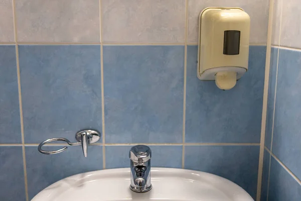 Lavabo et savon liquide pour les mains sur le mur dans la salle de bain de la chambre d'hôtel — Photo