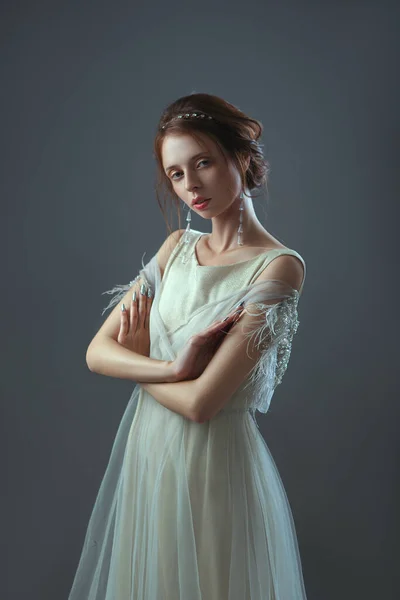 Emocjonalny staromodny portret dziewczyny w stylu retro w jasnej przezroczystej sukience z błyszczącymi elementami na ramionach. — Zdjęcie stockowe
