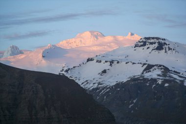 Güzel manzara. Bulutlu gökyüzüne karşı karlı dağlar