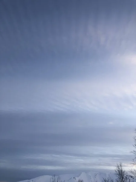 Bellissimo cielo blu tramonto con nuvole di piume sulle montagne — Foto Stock